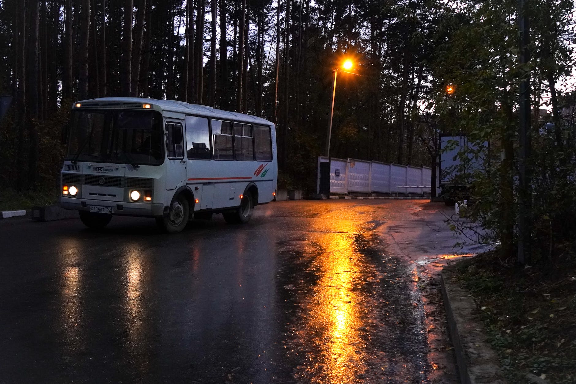 bus driving on rainy road in forest