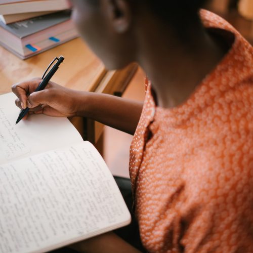 photo of woman writing on notebook